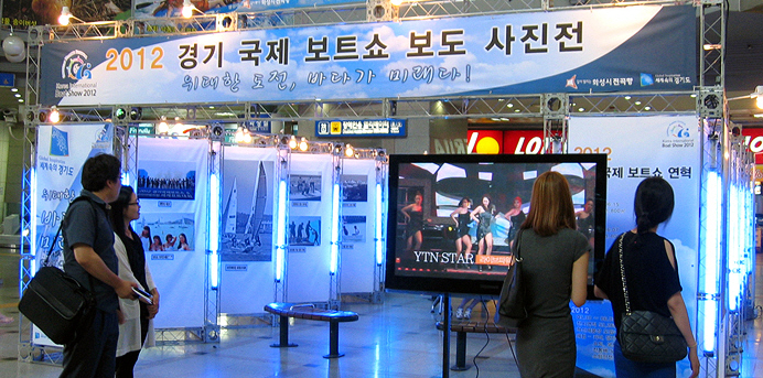 오가는 중 사진전에 관심을 보이는 도민들.