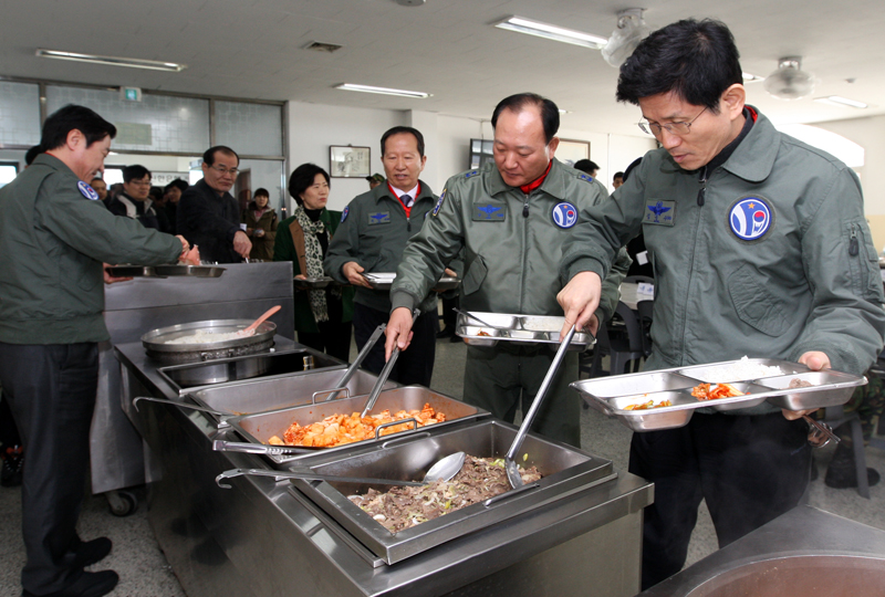 김 지사와 장 소장이 제10전투비행단 사병식당에서 일반사병 메뉴의 식사를 식판에 담고 있다.