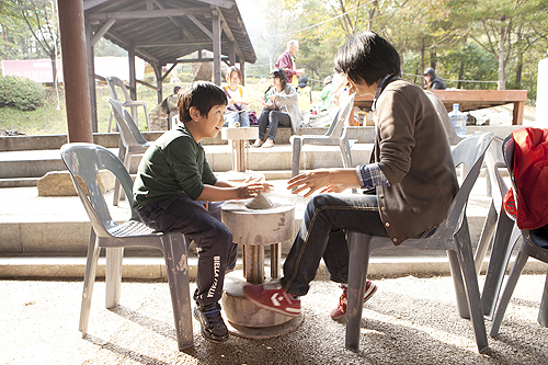 ‘2011 경기세계도자비엔날레’가 ‘구이구이 페스티벌’ 등 늦가을에 어울리는 새 프로그램들로 새단장을 했다. 이천세라피아에서 가족 관람객이 물레체험을 하고 있다.