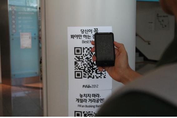 관람객 중 한 명이 스마트폰을 이용해 QR코드 스캔 후 정보를 제공받고 있다.