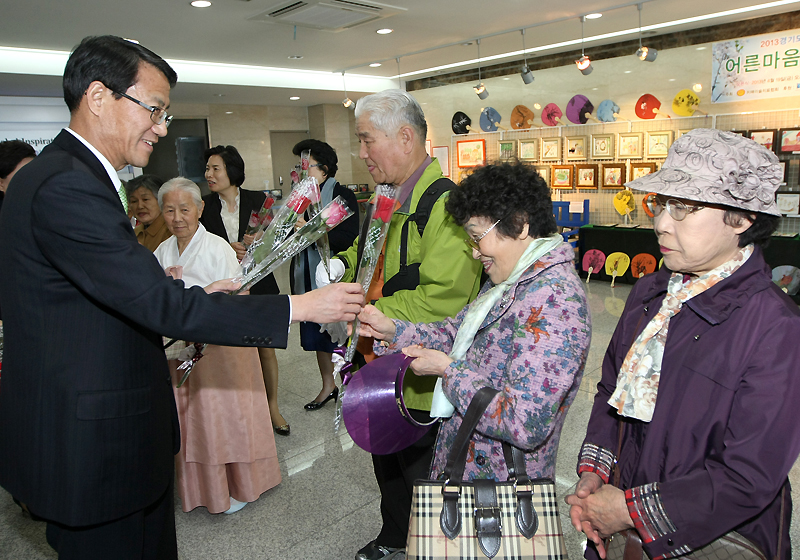 지난 19일 경기도청 제3별관 1층 ‘갤러리 별’에서 열린 <어른마음, 아이마음 전(展)> 개회식에서 김성렬 전 경기도 행정1부지사가 행사에 참석한 어르신들에게 꽃송이를 선물하고 있다.