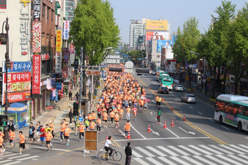 경기마라톤대회 참가자들이 주황물결을 이루며 수원 장안문 앞을 달리고 있다.