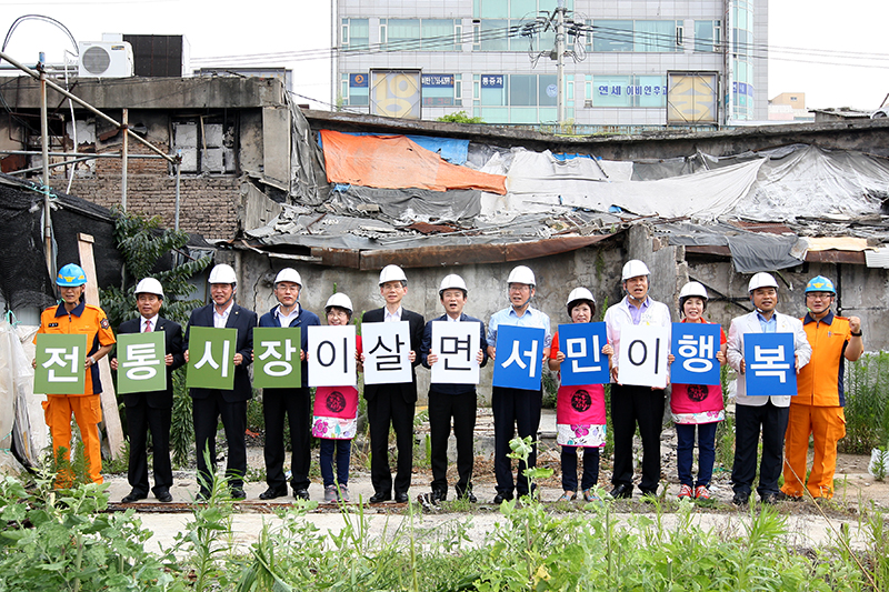 성남 중앙시장 화재현장에서 남경필 지사가 재난의 아픔을 딛고 재도약의 의지를 다지는 퍼포먼스를 하고 있다.