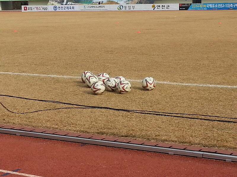 경기가 끝나고 선수들이 나간 자리에 축구공이 놓여있다.