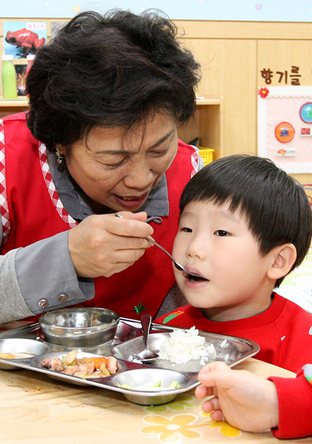 서호어린이집에서 박정란 국장이 아이들의 식사를 돕고 있다.