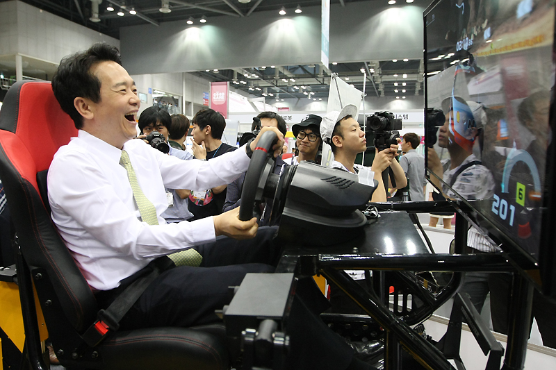 남 지사가 가상 운전 시뮬레이션 게임을 체험하며 즐거워하고 있다.