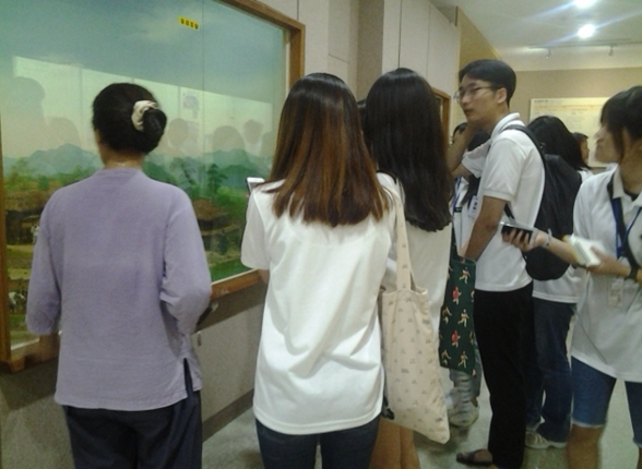 경기도 학생기자단이 농경문화 전시실에서 해설사의 해설을 듣고 있다