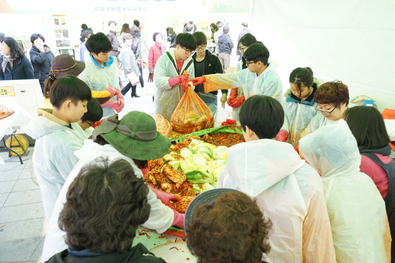 어려운 이웃에게 전달하는 사랑의 김장 나눔 행사에서 많은 참가자들이 김치를 담그고 있다.