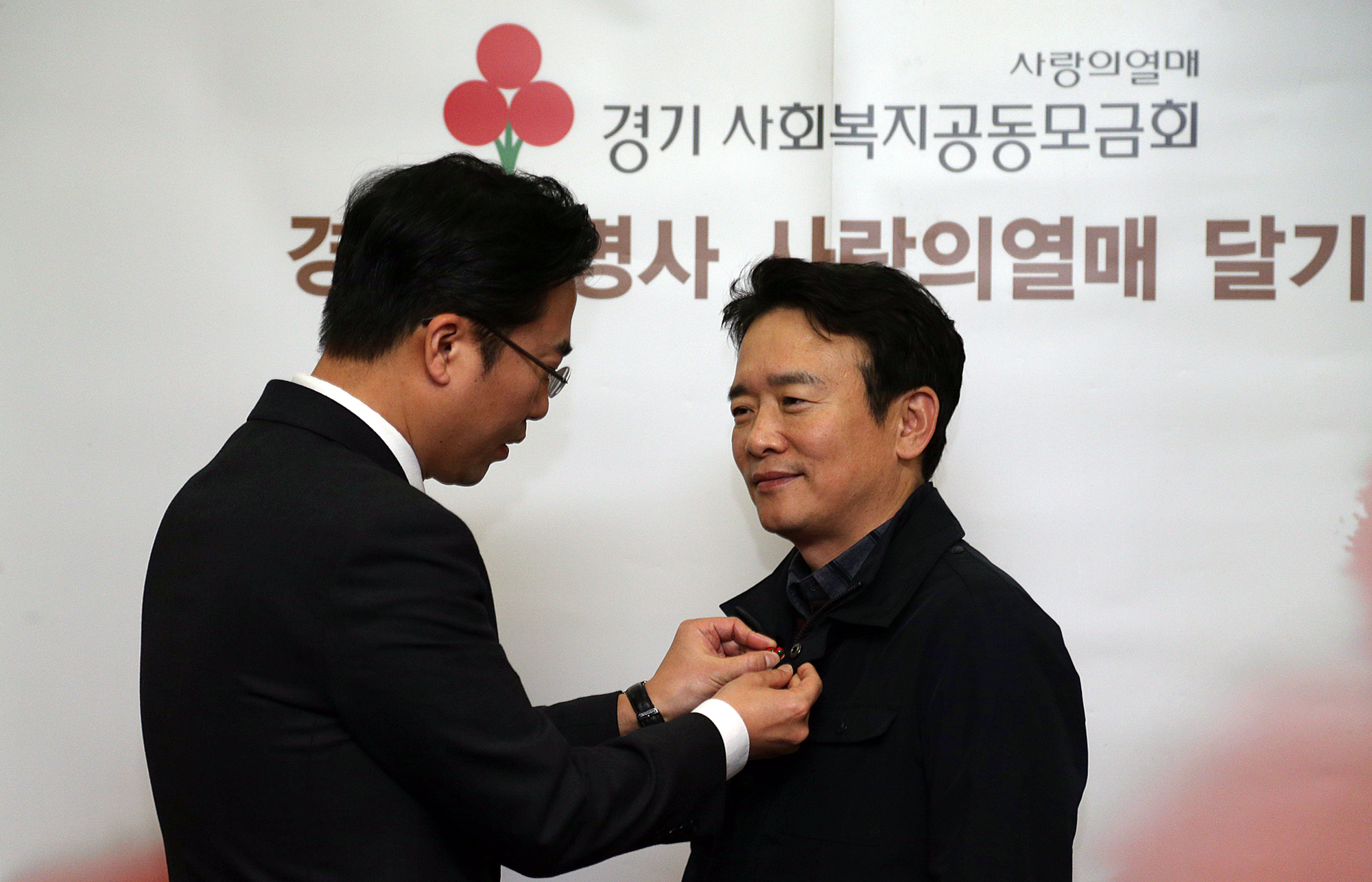 남경필 지사가 김효진 경기사회복지공동모금회 사무처장으로부터 사랑의 열매 배지를 받고 있다. 