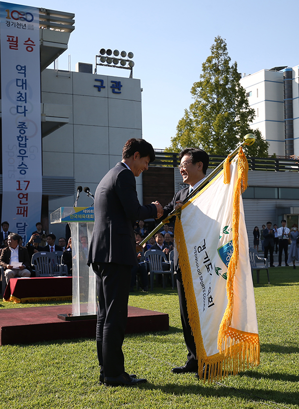 결단식에서 경기도체육회장인 이재명 지사가 박상현 총감독에게 선수단기를 전달하고 있다.