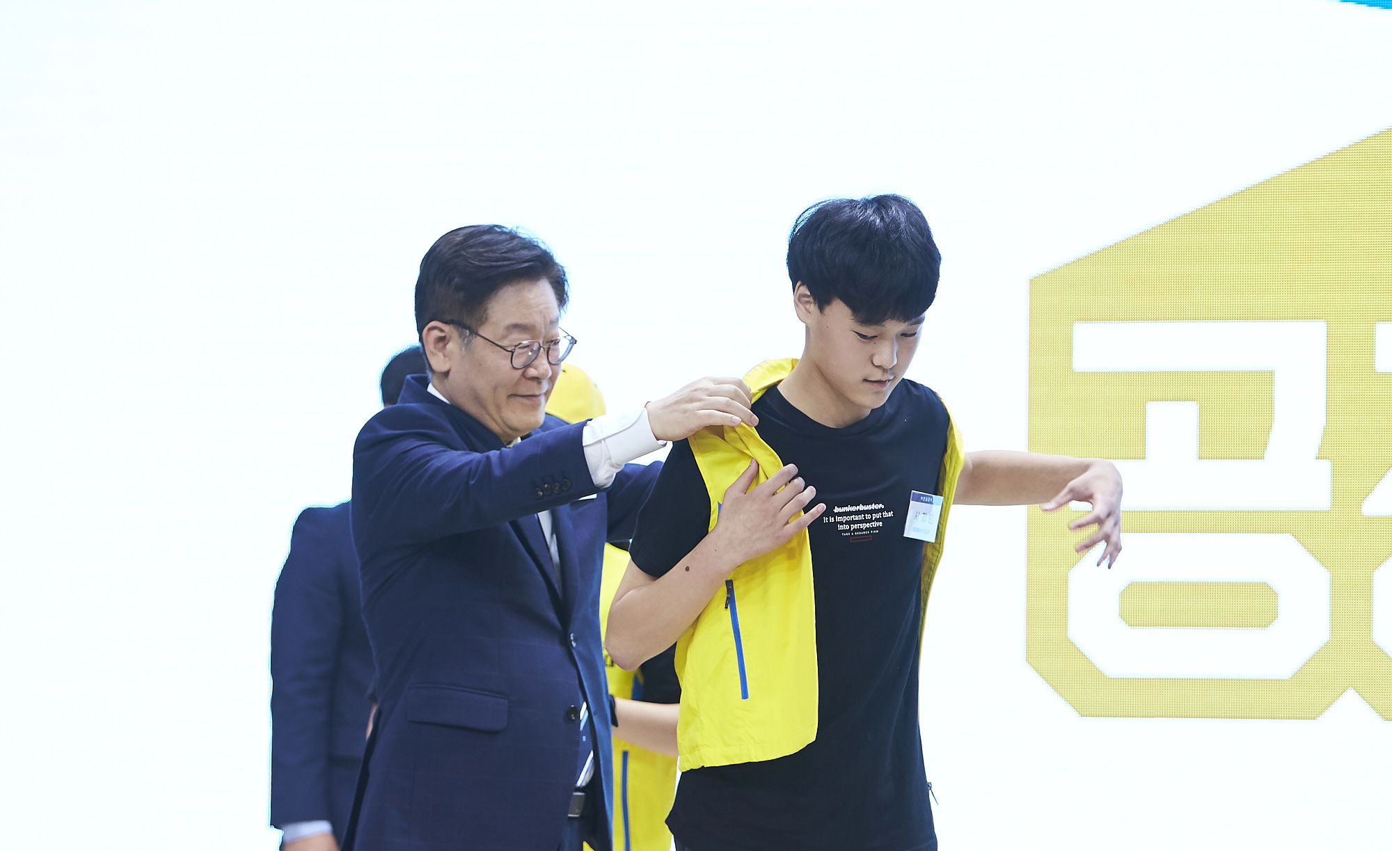 이재명 지사가 경기도 중학생 역사원정대 대표 단원에게 단복을 입혀주고 있다.