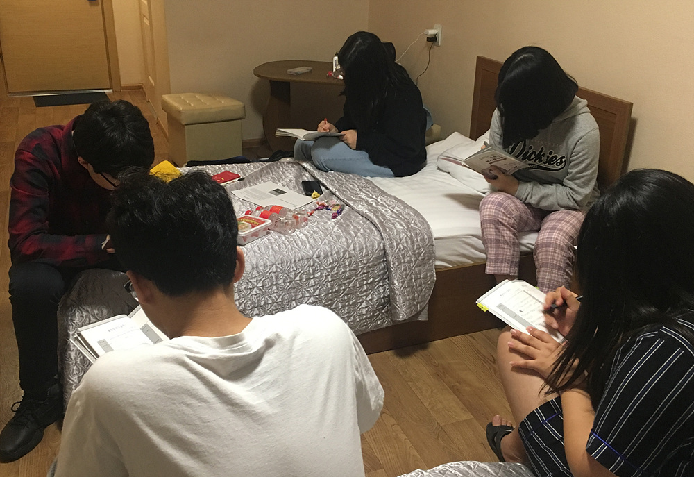 2조 학생들이 한 방에 모여 첫날의 활동일지를 작성하고 있다. 