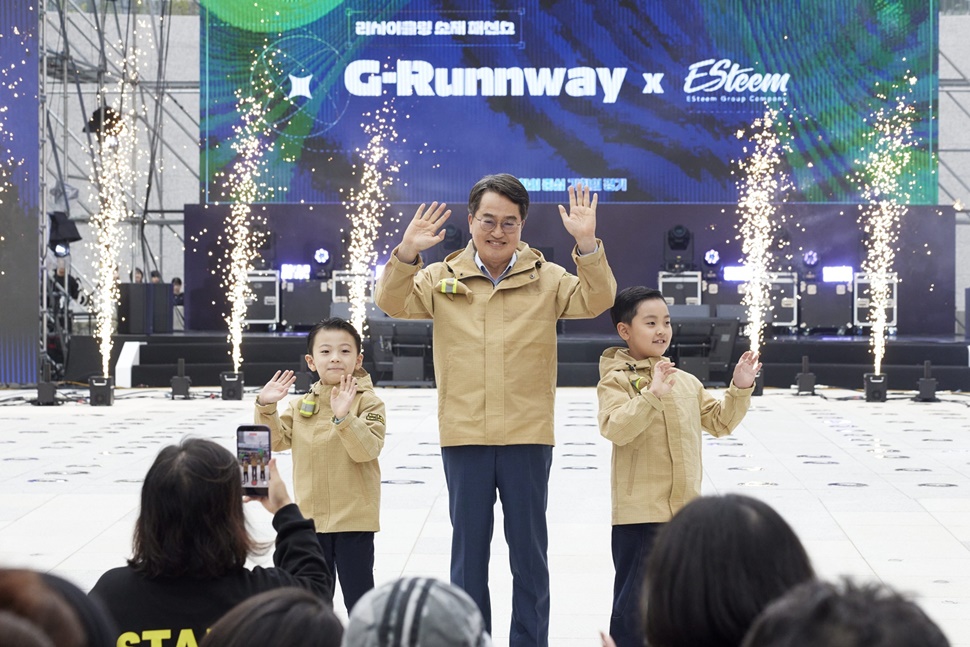 ‘지-런웨이(G-Runway)’에서 김동연 지사가 특별한 옷을 입고 무대에서 어린이 모델 2명과 함께 패션쇼 워킹을 하고 있다. ⓒ경기도청