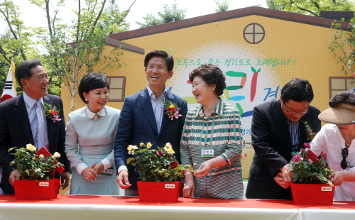 김문수 경기도지사가 11일 ‘내가 그린(Green) 경기도’ 기념행사장에서 경기정원문화대상 시상자들과 화분에 꽃을 담는 퍼포먼스를 한 후 밝게 웃고 있다.